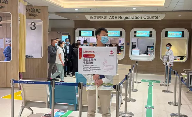 醫管局收費改革，有職員在廣華醫院急症室舉牌提示市民。資料圖片