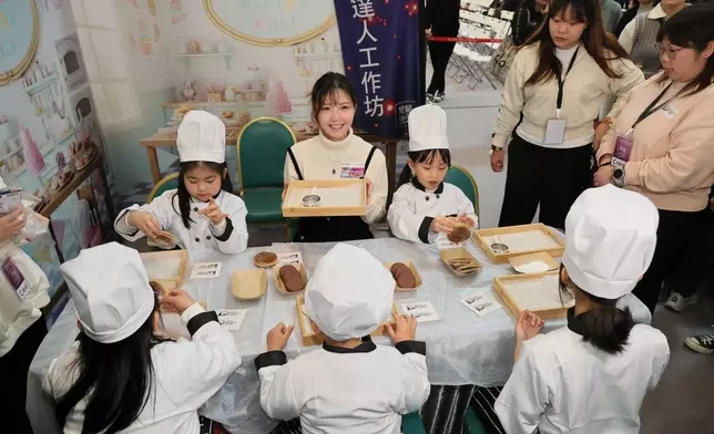 吳若希在親子「愛心理財工作坊」與扮小廚師的小朋友一齊整餅。