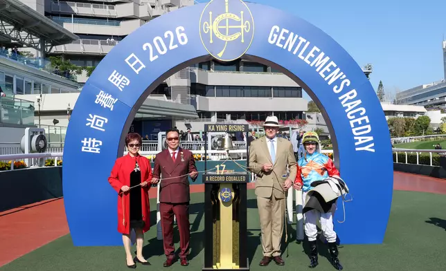 「嘉應高昇」追平「精英大師」的17連勝香港紀錄後，馬主代表梁錫光（左二）、練馬師大衛希斯（右二）及騎師潘頓（右一）一同敲響勝利鐘聲。馬會提供圖片 