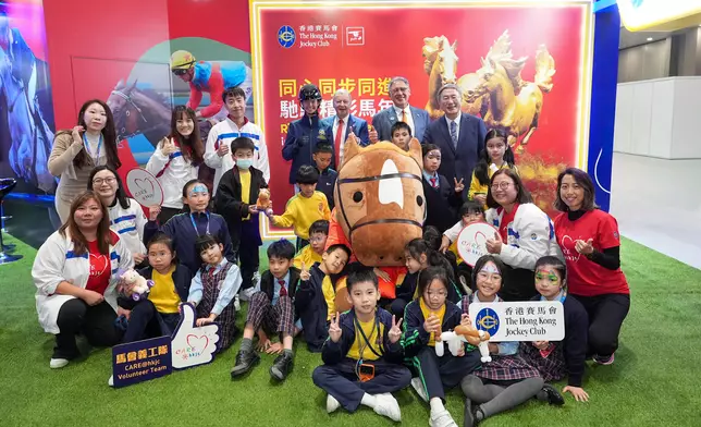 政務司副司長卓永興 (後排右一)、馬會副主席兼浪琴香港國際馬術盛典主席及中國香港馬術總會會長黃嘉純 (後排右二)、馬會行政總裁應家柏 (後排右三)及馬會青少年馬術隊成員王嘉莉 (後排右四)，與馬會義工隊及進場觀賽的青年及基層團體，於馬會互動攤位合照。