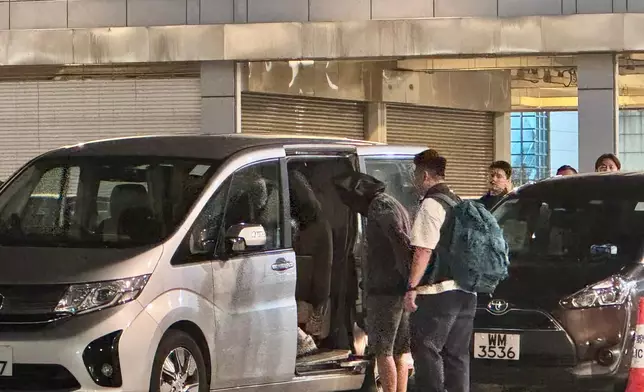 疑犯被警方押解上車。