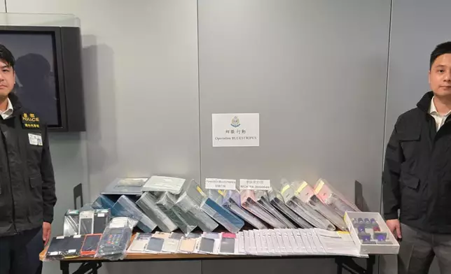 警方灣仔警區總督察(刑事)劉曉徽（左）及重案組督察佘軍霆（右）展示證物。