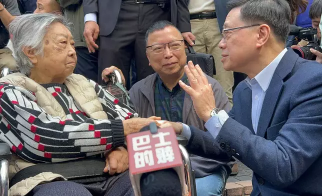 李家超期間蹲下與長者李太(坐輪椅者)及她兒子李生(中)傾談，並祝對方身體健康。巴士的報記者攝