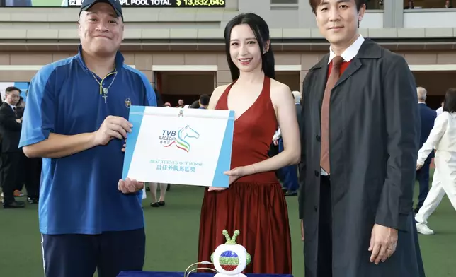 譚俊彥（右一）及龔嘉欣（右二）於馬匹亮相圈頒發最佳外觀馬匹獎予料理馬匹「信心星」的馬房助理。