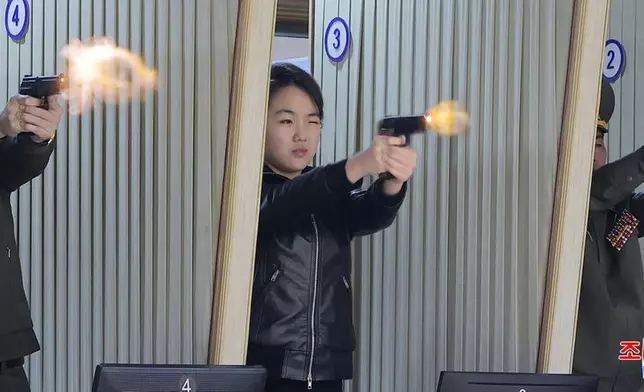 北韓政府提供的照片顯示，最高領導人金正恩的女兒（中）於2026年3月11日周三，在北韓某秘密地點的一家手槍及輕型武器生產工廠試射新型手槍。AP圖片