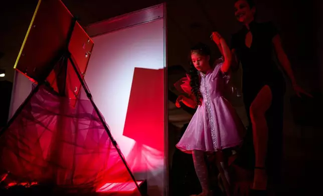 露伊莎歌蘭嘉（Luiza Coranga）（右）協助其姊妹瑪麗亞（Maria）走上天橋，攝於2026年3月18日（周三），在羅馬尼亞布加勒斯特舉行的「SEEN匿名裁縫晚會」（SEEN Anonymous Seamstresses Gala）。該活動由「唐氏綜合症加布加勒斯特」（Down Plus Bucharest）舉辦，旨在支援唐氏綜合症及其他智力障礙的年輕人。3月21日為世界唐氏綜合症日（World Down Syndrome Day）。 (美聯社圖片/Andreea Alexandru) AP圖片