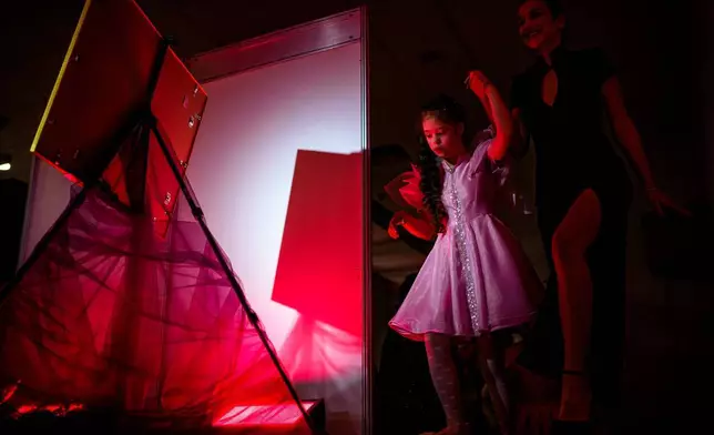 露易莎科蘭加（Luiza Coranga，右）在SEEN匿名裁縫師慈善晚會期間協助妹妹瑪麗亞（Maria）踏上天橋。這是在2026年3月18日周三，世界唐氏綜合症日（3月21日）前夕，於羅馬尼亞首都布加勒斯特舉行的SEEN匿名裁縫師慈善晚會上拍攝。該活動由布加勒斯特唐氏綜合症加強協會（Down Plus Bucharest）組織，該協會是一個支援唐氏綜合症及其他智力障礙年輕人的非政府組織。(美聯社圖片/Andreea Alexandru) AP圖片