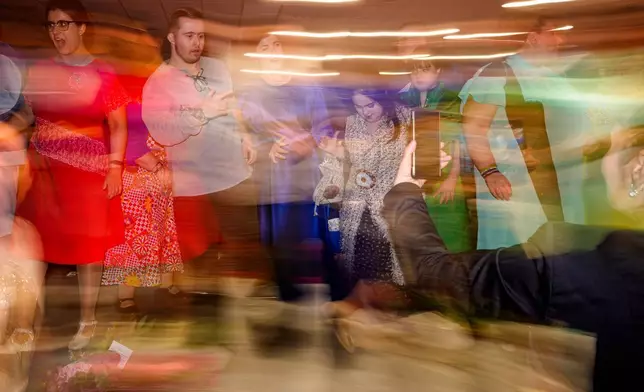 年輕人在SEEN匿名裁縫師慈善晚會結束時在天橋上跳舞。這是在2026年3月18日周三，世界唐氏綜合症日（3月21日）前夕，於羅馬尼亞首都布加勒斯特舉行的SEEN匿名裁縫師慈善晚會上拍攝。該活動由布加勒斯特唐氏綜合症加強協會（Down Plus Bucharest）組織，該協會是一個支援唐氏綜合症及其他智力障礙年輕人的非政府組織。(美聯社圖片/Andreea Alexandru) AP圖片