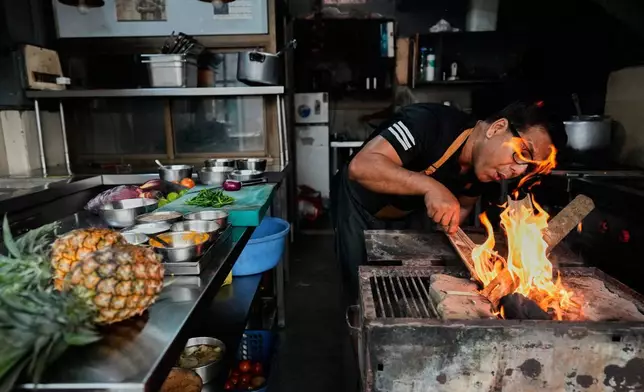 2026年3月19日周四，印度古瓦哈蒂，來自阿薩姆地區的廚師阿圖爾拉赫卡爾（Atul Lahkar）因地區性燃氣短缺，正用木材和煤炭生火為其餐廳準備食物。(美聯社圖片/Anupam Nath) AP圖片