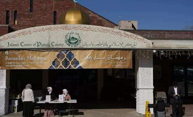 2026年2月27日周五，新澤西州帕特森，莉恩謝拉（Leen Shella）（中）和哈寧艾拉蒂亞特（右）在齋戒月期間，於帕塞伊克縣伊斯蘭中心外準備鼓勵信眾在新澤西州初選中投票。(美聯社圖片/Luis Andres Henao) AP圖片