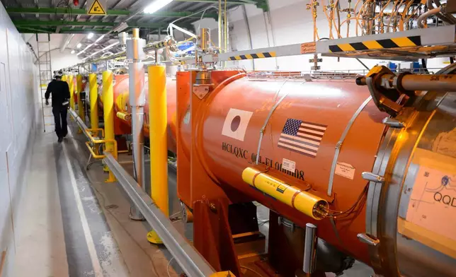 (Laurent Gillieron/Keystone via 美聯社圖片, 檔案照) 2016年2月16日，瑞士日內瓦附近的梅蘭，歐洲核子研究組織（CERN）的大型強子對撞機（LHC）隧道內，一名技術人員在新聞參觀期間工作。 AP圖片