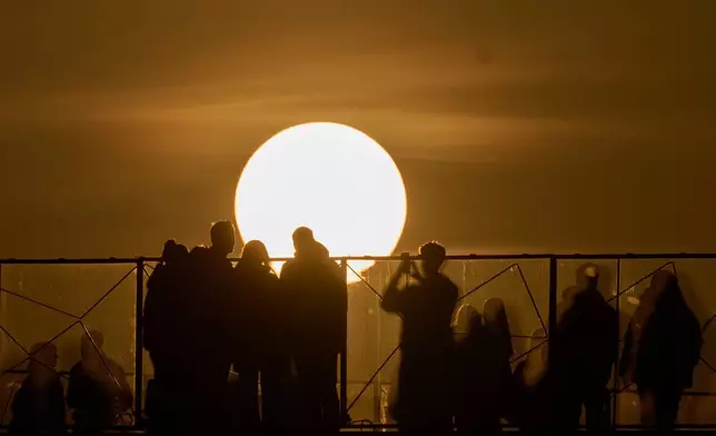 2026年3月12日周四，莫斯科日落時分，民眾在觀賞及拍照。(美聯社圖片/Alexander Zemlianichenko) AP圖片