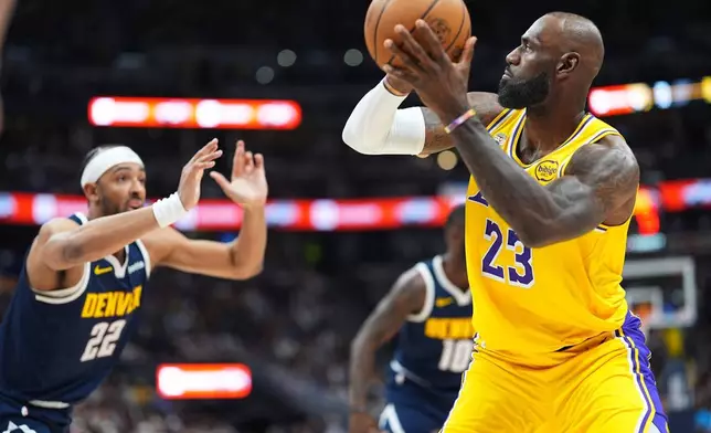 洛杉磯湖人前鋒勒邦占士（右）在NBA籃球賽上半場中，面對丹佛金塊前鋒錫克拿治的防守，起跳投籃，超越渣巴15837個入球的紀錄，成為NBA歷史上入球最多的球員。AP圖片