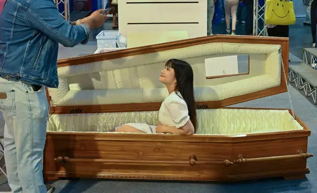 2026年3月13日周五，一名參觀者在泰國暖武里府的「死亡節」中坐在棺材內拍照。(美聯社圖片/Kittinun Rodsupan) AP圖片