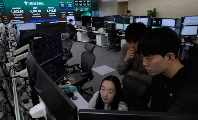 在南韓首爾韓亞銀行總部的外匯交易室內，貨幣交易員正觀看屏幕。 AP圖片