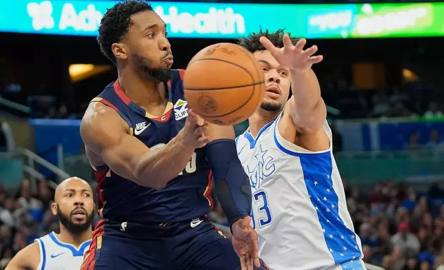 騎士後衛米曹（Donovan Mitchell，左）避開魔術前鋒賓達（Noah Penda）傳球。 AP圖片