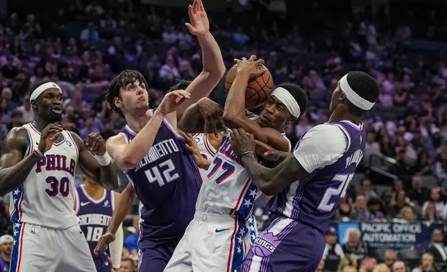 薩克拉門托帝王中鋒雷諾（Maxime Raynaud，42號）與費城76人後衛艾治甘比（Vj Edgecombe，77號）在NBA籃球賽上半場爭搶籃板。AP圖片