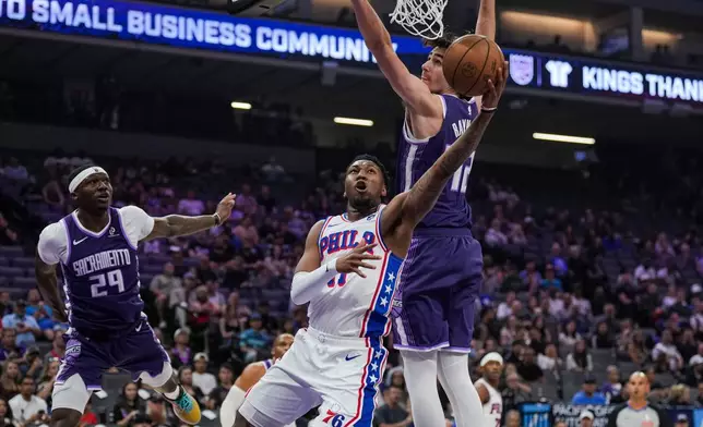 費城76人前鋒艾華士（Justin Edwards，前）在NBA籃球賽上半場上籃，對抗薩克拉門托帝王中鋒雷諾（Maxime Raynaud，後右）。(AP圖片