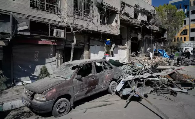 工人檢查一幢受損建築物，位於美國—以色列軍事行動中被擊中的警署設施對面，攝於伊朗德黑蘭，2026年3月4日周三。(美聯社圖片/Vahid Salemi) AP圖片