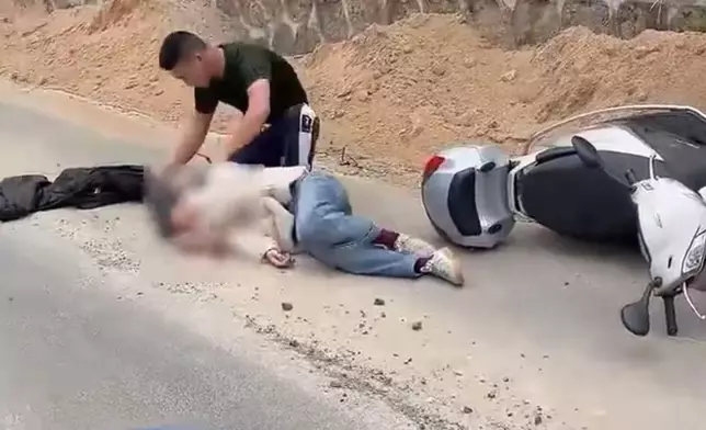 女子騎電單車側翻頭部重創血流不止，獲休假武警及時施救轉危為安。影片截圖
   x