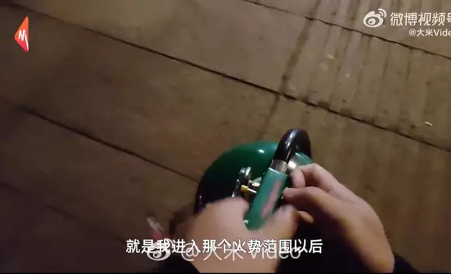 男子陪妻睇電影路上遇草坪起火即停車掏20斤滅火器滅火。影片截圖