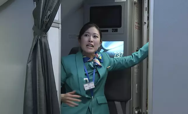 機場舉行年度飛機事故演練，空服員指示乘客疏散離開。機管局圖片