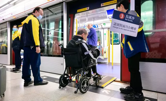港鐵職員協助有特別需要的乘客包括視障及使用輪椅的乘客轉車。