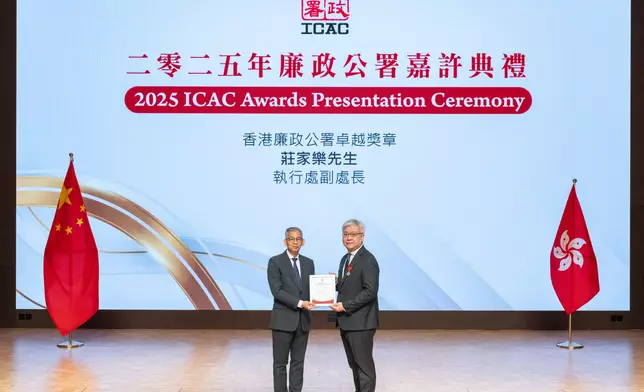 廉政專員胡英明(左)頒發紀念品予早前獲政府頒發廉政公署卓越獎章的執行處處長(私營機構)莊家樂(右)。署圖片