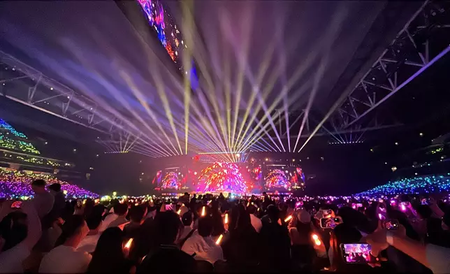 演唱會現場歌迷揮舞螢光棒形成燈海。