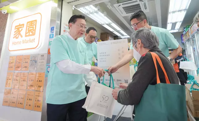 恒基地產執行董事兼家園基金董事孫國林於家園便利店，與義工一同向市民派發福袋。