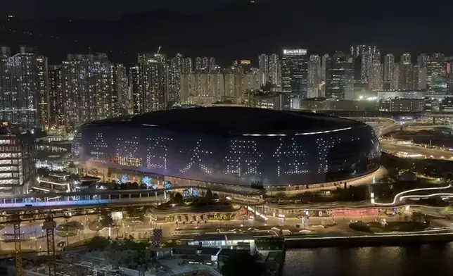 啟德體育園主場館外牆熒幕以中英文分別展示「啟德體育園榮膺《時代》雜誌2026全球百大最佳勝地」的字樣。