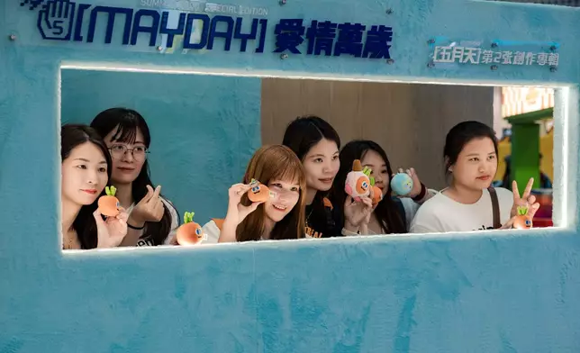 不少歌迷手持應援物在「打卡位」拍照留念。