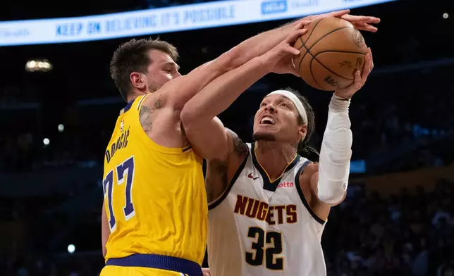 洛杉磯湖人隊後衛盧卡當錫（左）封阻丹佛金塊隊前鋒艾朗哥頓的投籃。AP圖片