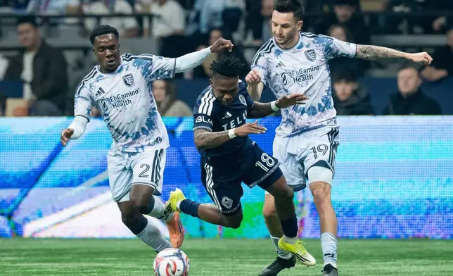 聖荷西地震隊的列基斯（Jamar Ricketts，左）和賈德（Preston Judd，中）在2026年3月21日周六於溫哥華舉行的一場美職聯（MLS）足球賽上半場絆倒溫哥華白帽隊的奧甘普（Edier Ocampo，右）。(美聯社圖片/Ethan Cairns/The Canadian Press) AP圖片