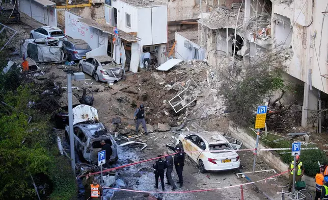 以色列安全及救援部隊，2026年3月24日周二在以色列特拉維夫的伊朗導彈襲擊現場應變。AP圖片