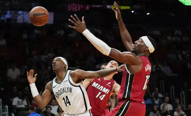 布魯克林籃網後衛泰倫斯曼（14號）失去控球權，邁阿密熱火中鋒巴姆艾迪巴約（13號）防守。AP圖片