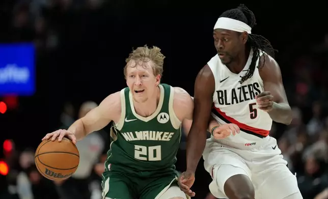 2026年3月25日周三，在俄勒岡州波特蘭舉行的一場NBA籃球賽上半場，密爾沃基公鹿隊後衛格林（AJ Green）（20號）嘗試突破波特蘭拓荒者隊後衛賀利迪（Jrue Holiday）（5號）。（美聯社圖片/Jenny Kane） AP圖片