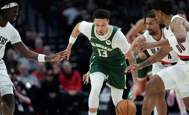 2026年3月25日周三，在俄勒岡州波特蘭舉行的一場NBA籃球賽上半場，密爾沃基公鹿隊後衛羅林斯（Ryan Rollins）（13號）在波特蘭拓荒者隊球員包圍下爭球。（美聯社圖片/Jenny Kane） AP圖片