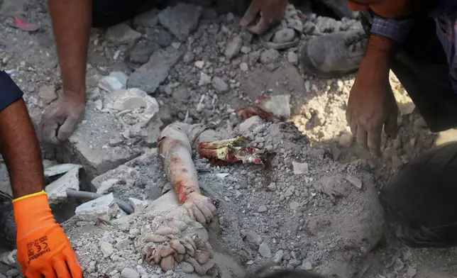 2026年2月28日周六，伊朗米納卜（Minab）一間女子小學遭襲擊後，救援人員及居民在瓦礫中搜救，現場見到一名死者的手臂伸出。 AP圖片