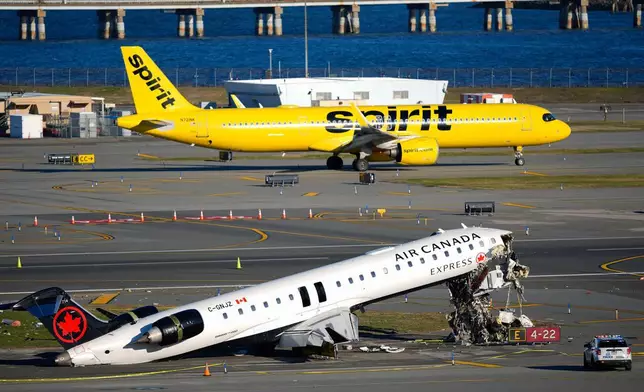 一架精神航空（Spirit Airlines）客機周二（2026年3月24日）滑行經過停留在跑道旁的加拿大航空快運（Air Canada Express）客機。該客機周日深夜在紐約拉瓜迪亞機場（LaGuardia Airport）與一輛紐約與新澤西港務局（Port Authority）消防車相撞。(美聯社圖片/Yuki Iwamura) AP圖片