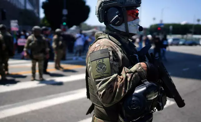檔案圖片：2025年6月10日周二，在洛杉磯（Los Angeles）市中心的大都會拘留中心（Metropolitan Detention Center）外，一名美國移民及海關執法局（ICE）特別應變小組成員站崗，同時示威者聚集在外譴責美國移民及海關執法局的行動。（美聯社圖片/Eric Thayer） AP圖片