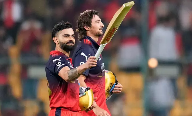 2026年3月28日，周六，印度班加羅爾，印度超級板球聯賽皇家挑戰者班加羅爾擊敗太陽升海得拉巴的板球比賽後，皇家挑戰者班加羅爾的維拉高利（左）與隊友添大衛（Tim David）離場時向球迷示意。（美聯社圖片/Aijaz Rahi） AP圖片