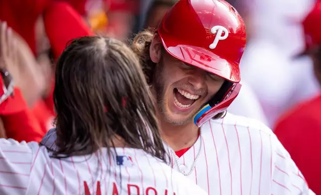 2026年3月26日周四，費城一場對陣德州遊騎兵隊（Texas Rangers）的棒球開幕戰的第五局，費城費城人隊（Philadelphia Phillies）的艾力寶姆（Alec Bohm）（右）與布蘭登馬殊（Brandon Marsh）（左）慶祝他的三分全壘打。(美聯社圖片/Chris Szagola) AP圖片