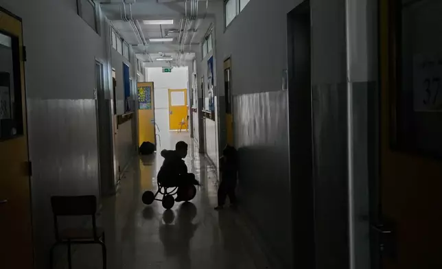 2026年3月10日周二，黎巴嫩貝魯特，一名隨家人逃離以色列對黎巴嫩南部空襲的男孩，在已改建為收容中心的學校教室走廊騎單車玩耍。(美聯社圖片/Hussein Malla) AP圖片