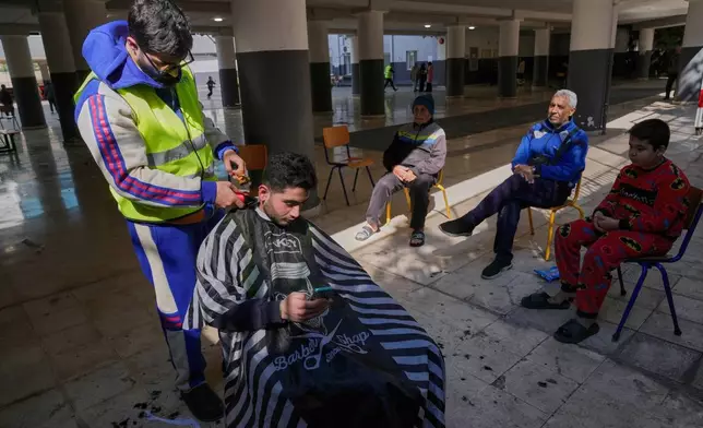 2026年3月10日周二，黎巴嫩貝魯特，一名逃離以色列對黎巴嫩南部空襲的男子，在已改建為收容中心的學校操場理髮。(美聯社圖片/Hussein Malla) AP圖片