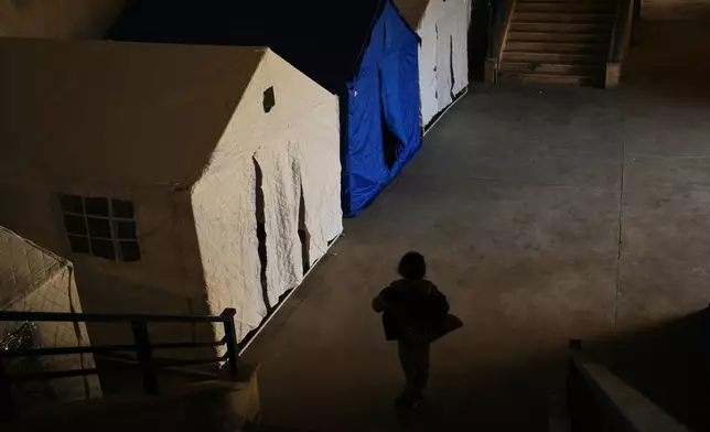 2026年3月10日周二，黎巴嫩貝魯特，一名流離失所的兒童走過卡米勒夏蒙體育城體育場（Camille Chamoun Sports City Stadium）內的帳篷。該體育場已改建為收容中心，安置因以色列空襲黎巴嫩南部及貝魯特南郊達希耶（Dahiyeh）而逃難的民眾。(美聯社圖片/Hassan Ammar) AP圖片