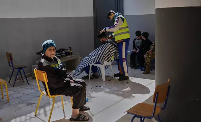 2026年3月10日周二，黎巴嫩貝魯特，一名逃離以色列對黎巴嫩南部空襲的男子，在已改建為收容中心的學校操場理髮。(美聯社圖片/Hussein Malla) AP圖片