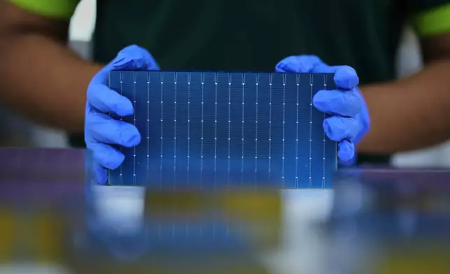 資料圖片：2025年8月21日周四，印度齋浦爾（Jaipur）市郊的ReNew製造廠，一名工人堆疊單個太陽能電池。(美聯社圖片/Manish Swarup) AP圖片