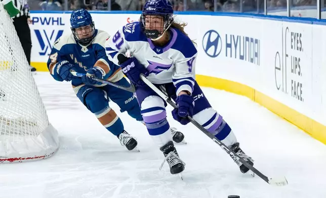 明尼蘇達冰霜的佩頓安德森（91號）在2026年3月21日周六，加拿大卑詩省溫哥華舉行的一場職業女子冰球聯賽（PWHL）比賽第三節中，持球推進，溫哥華金眼隊的安娜邁克斯納（94號）防守。(美聯社圖片/Ethan Cairns/The Canadian Press) AP圖片