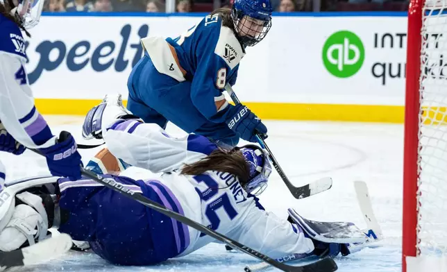 明尼蘇達冰霜門將瑪迪盧尼（35號）在2026年3月21日周六，加拿大卑詩省溫哥華舉行的一場職業女子冰球聯賽（PWHL）比賽第三節中，阻截溫哥華金眼隊的伊茲丹尼爾（8號）。(美聯社圖片/Ethan Cairns/The Canadian Press) AP圖片
